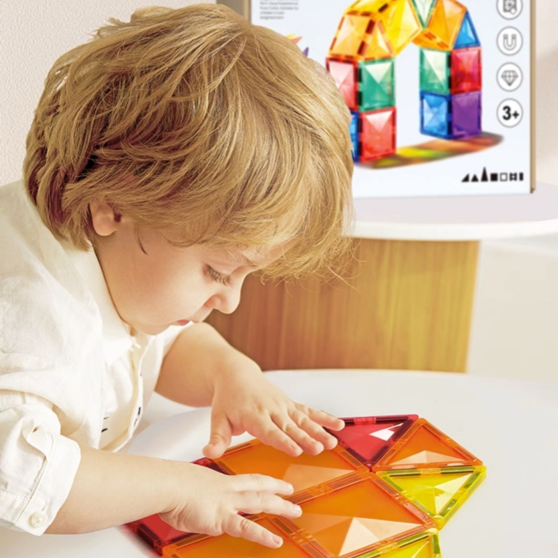 a kid is playing the magnetic building blocks