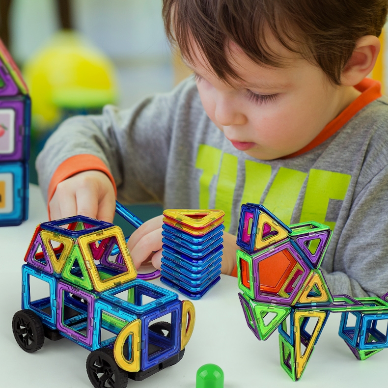 a kid playing magnetic building blocks